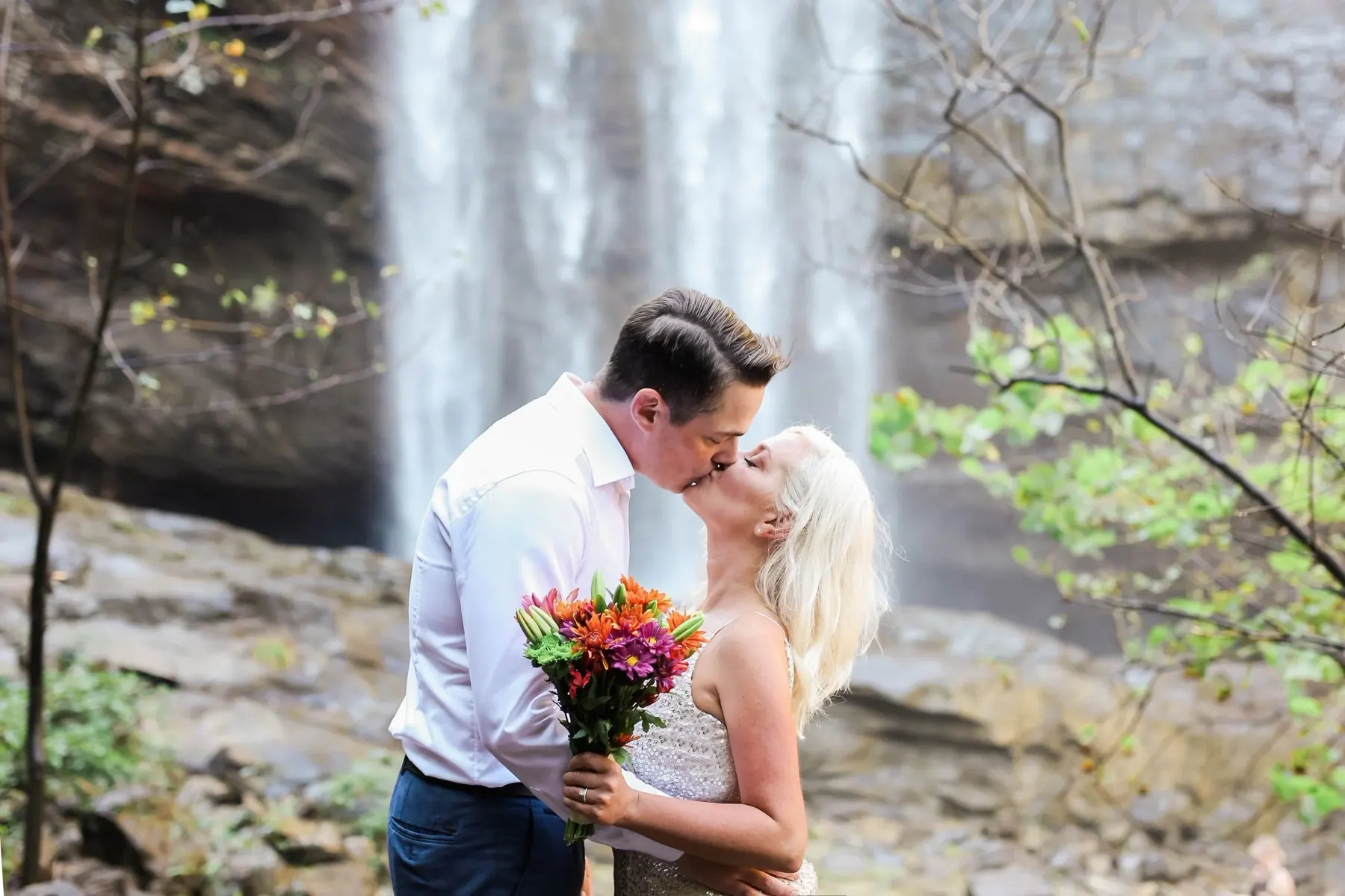 Couple kissing near a waterfall in Jami Ferguson's wedding portfolio